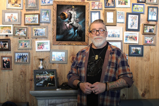 Garry Boyd in front of the ‘family wall’ at The Unicorn Tavern.