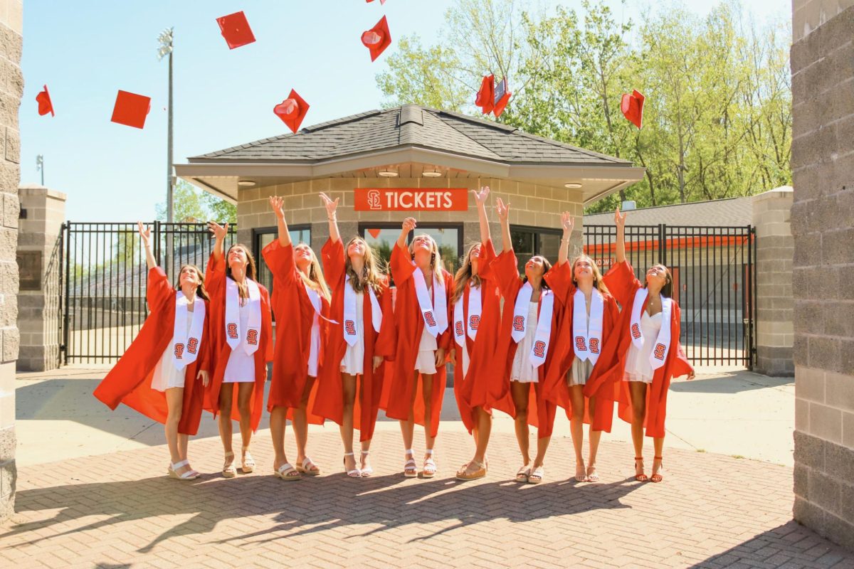 Graduates toss their caps as they prepare for the ceremony held on Wednesday. 