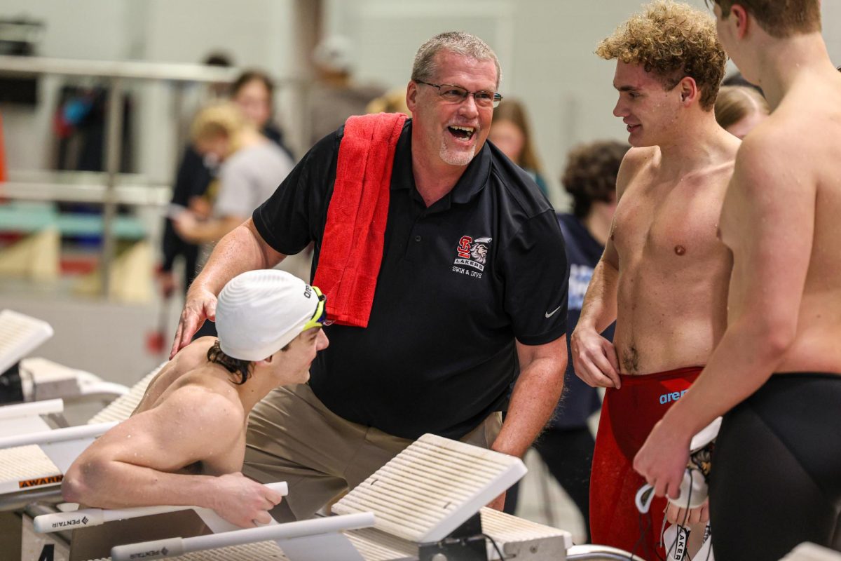 Head Coach Mick Homan celebrates with his No. 1, undefeated swimmers at the Senior Night meet. 